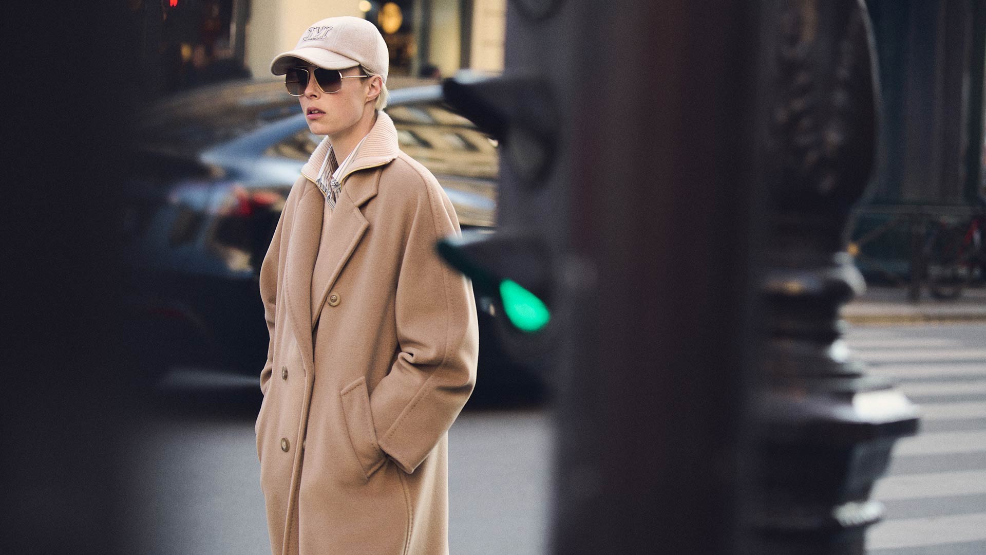Model in Max Mara 101801 long icon coat in camel colour, paired with dark glasses and hat.